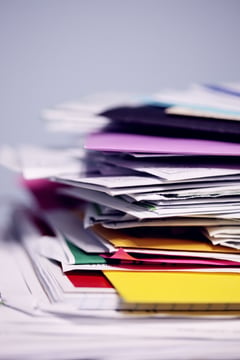 Stapel papieren en enveloppen op een bureau