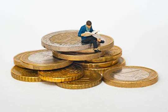 Stapel euromunten met een klein figuurtje erop