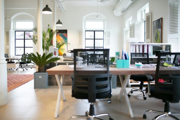 Leeg kantoor met onbezette bureaus en stoelen