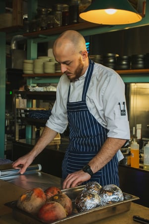 Kok in een schort aan het werk in een restaurantkeuken