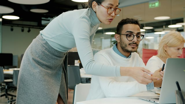 Collega’s bespreken samen gegevens op een laptop